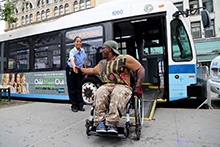 person in wheelchair by bus